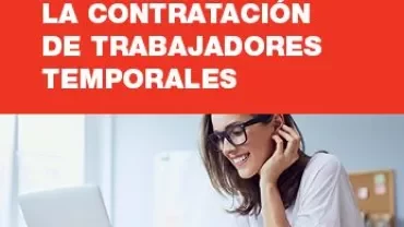 Persona sonriente trabajando en una computadora portátil en una oficina.