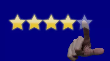 Se muestra una mano seleccionando una estrella en una fila de cinco estrellas.