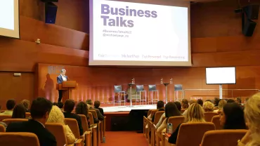 Conferencia Business Talks con un orador en el podio.