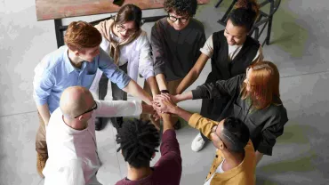 Grupo de personas uniendo manos en equipo.