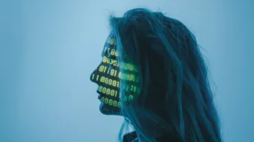 Perfil humano con proyección de códigos binarios en el rostro.