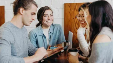 Grupo de personas sonrientes en una reunión informal.