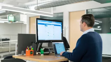 Profesional actualizando su perfil de LinkedIn en un ordenador portátil.