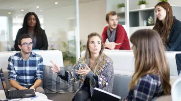Grupo de personas en reunión de trabajo en oficina moderna.
