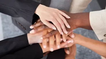 Manos apiladas simbolizando unidad.