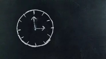 Dibujo de reloj en una pizarra, mostrando las dos y diez.