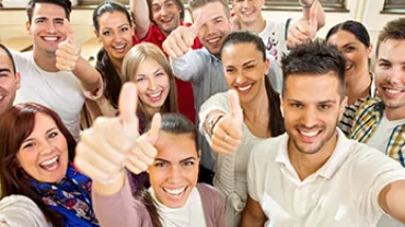 Grupo de personas sonrientes levantando el pulgar.