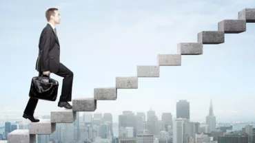 Persona subiendo escaleras de piedra sobre una ciudad.