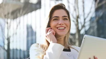 Persona sonriendo con una tablet en mano.