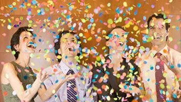 Personas celebrando bajo una lluvia de confeti.