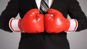 Persona en traje con guantes de boxeo rojos.