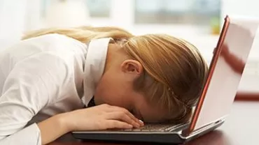 Persona con la cabeza sobre el teclado de una laptop.