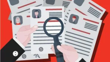 Manos sosteniendo una lupa sobre un currículum.