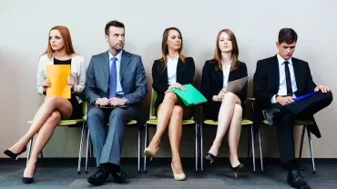 Cinco personas sentadas en una sala de espera.