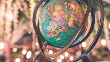 Globo terráqueo con enfoque en África y Europa, rodeado de luces borrosas.