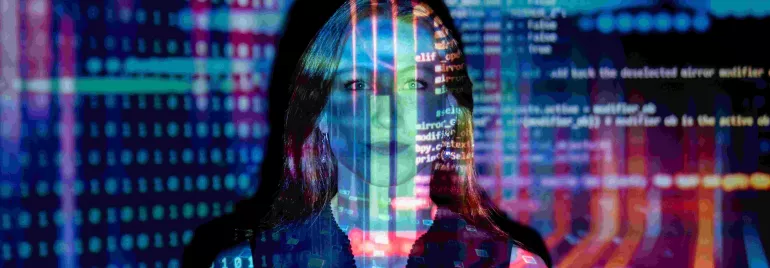 Persona en pantalla proyectada con código y gráficos digitales.