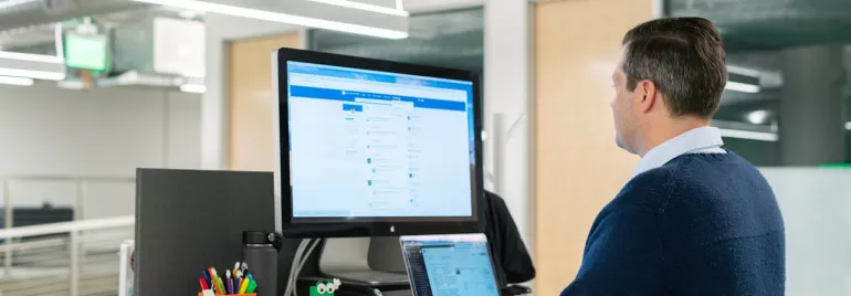 Profesional actualizando su perfil de LinkedIn en un ordenador portátil.