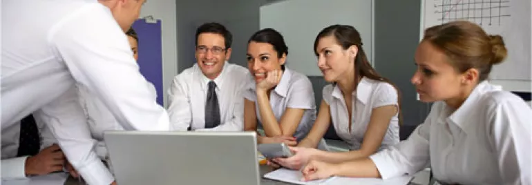 Reunión de equipo con personas interactuando alrededor de una mesa.