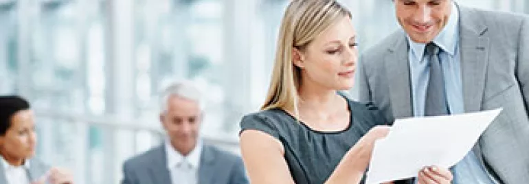 Personas revisan documentos en una oficina moderna.