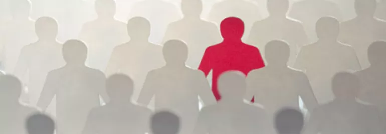 Figura roja destaca entre siluetas grises.