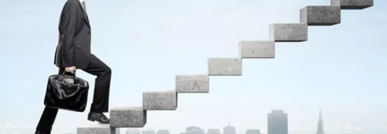 Persona subiendo escaleras de piedra sobre una ciudad.