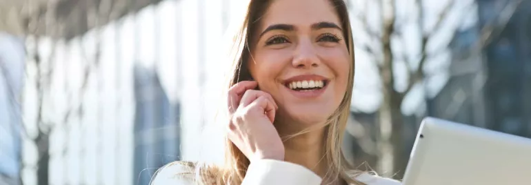 Persona sonriendo con una tablet en mano.