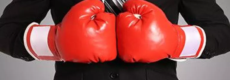 Persona en traje con guantes de boxeo rojos.