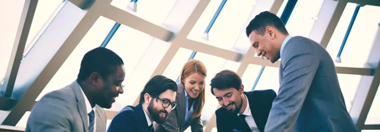 Personas en una reunión de trabajo, sonriendo y discutiendo.