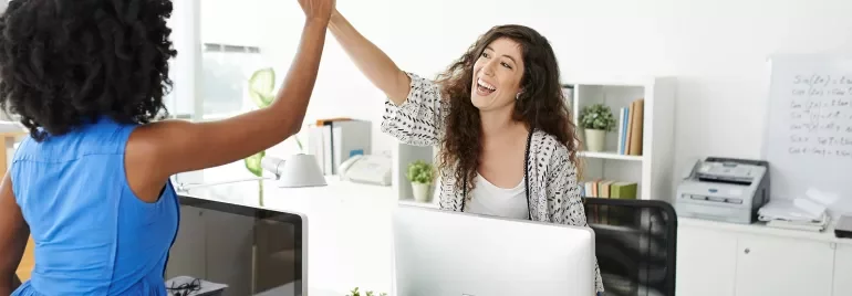 Personas chocando las manos en una oficina moderna.