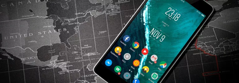 Teléfono móvil en pantalla principal sobre mapa mundial.