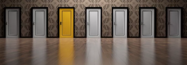 Fila de puertas grises con una puerta amarilla resaltando.