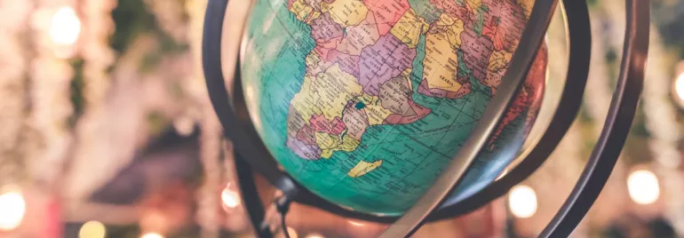 Globo terráqueo con enfoque en África y Europa, rodeado de luces borrosas.