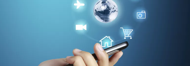 Mano sosteniendo un teléfono con íconos digitales alrededor.