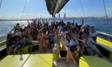 Grupo de personas celebrando en un barco bajo el sol.